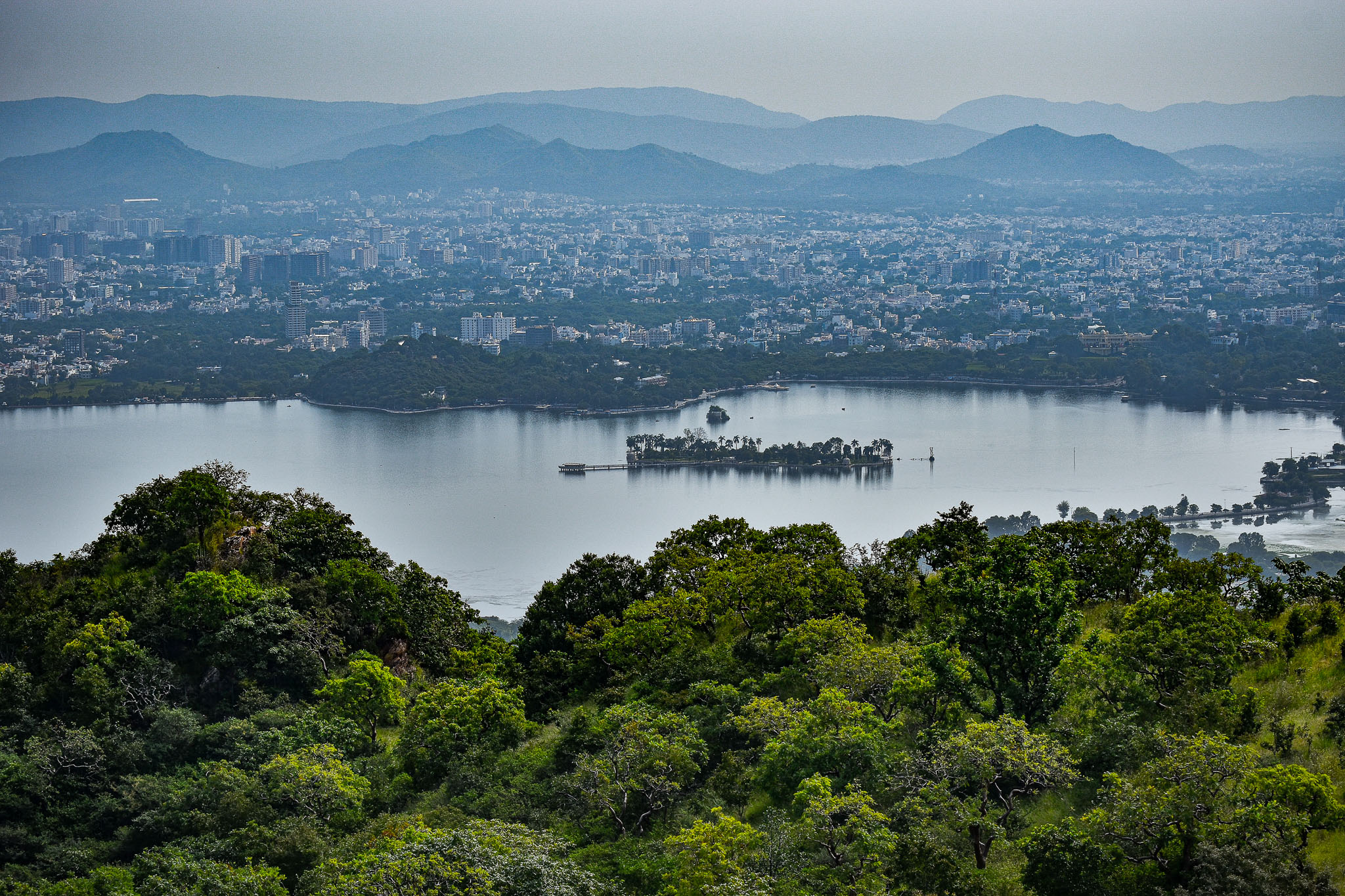 Udaipur lake cityscape with buildings reflected near the water.